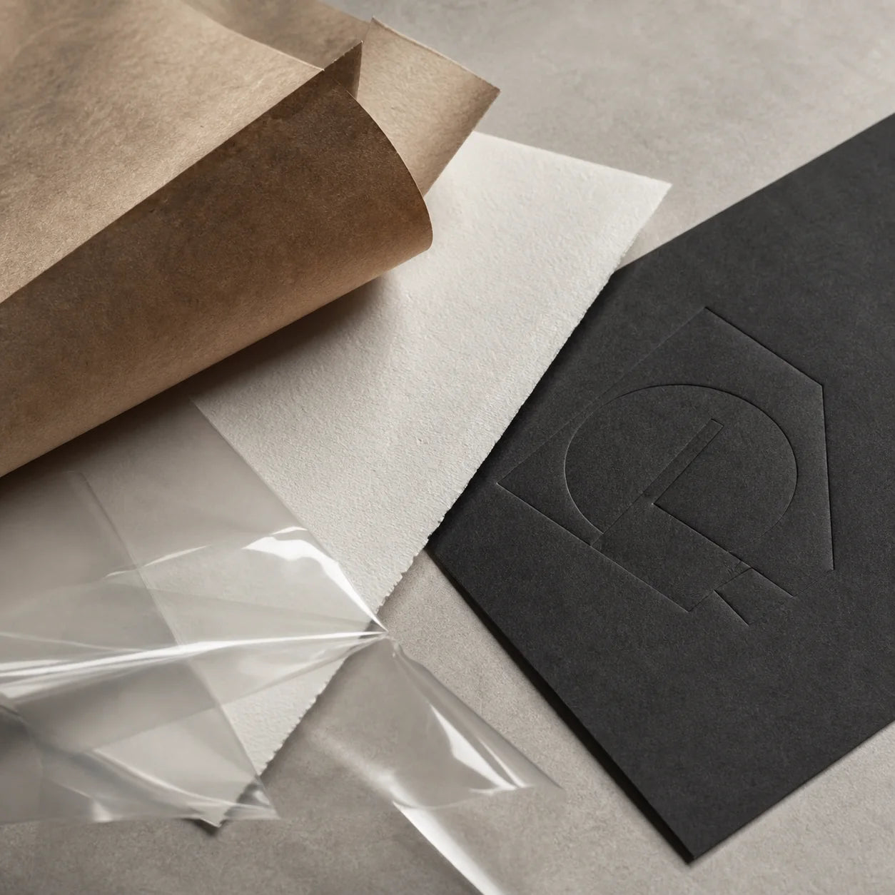 Close-up of kraft, white, clear, and charcoal packaging materials
